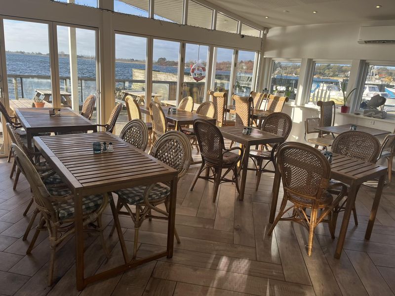 Borde og kurvestole i caféen med udsigt til havnen